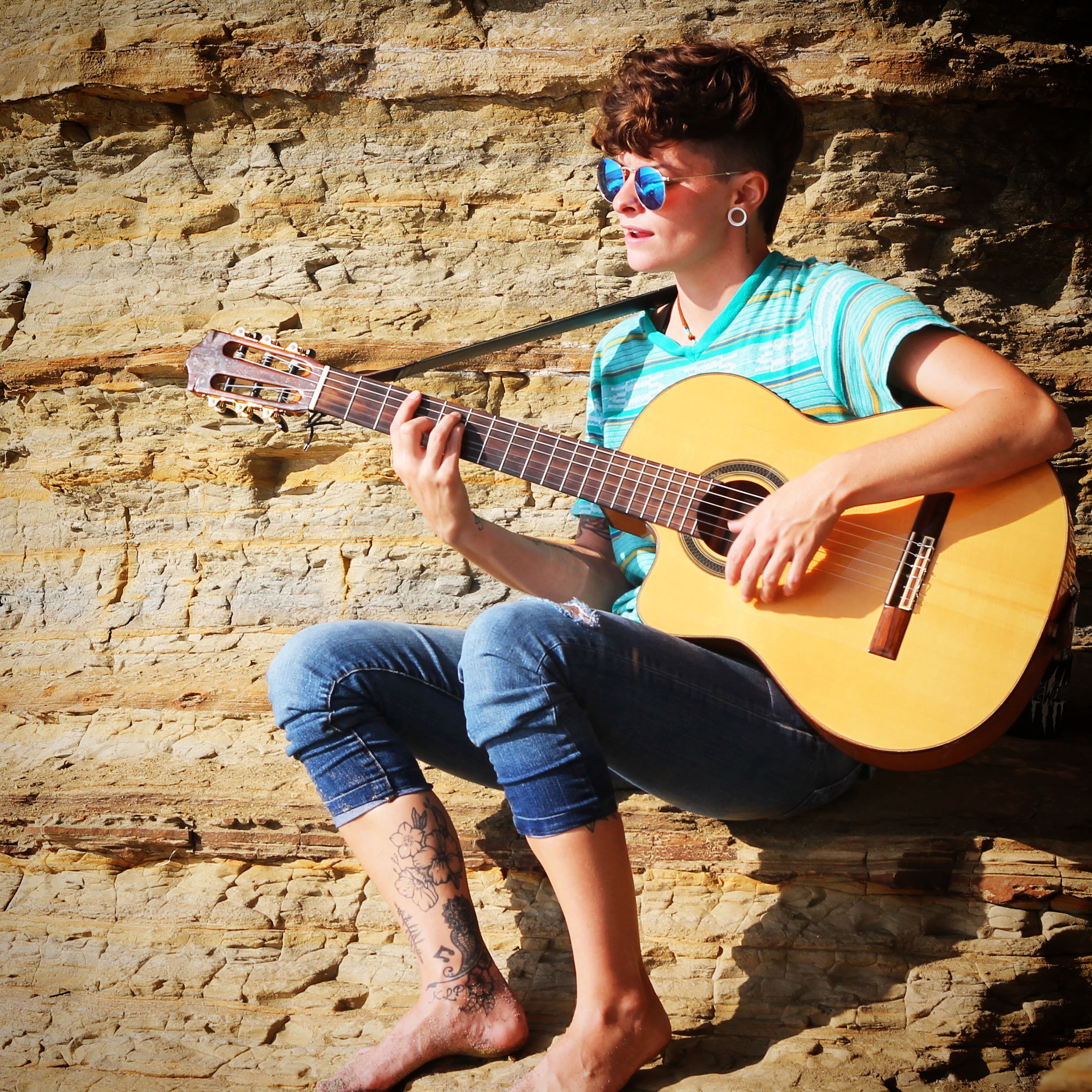 Haley playing guitar sitting on mountain